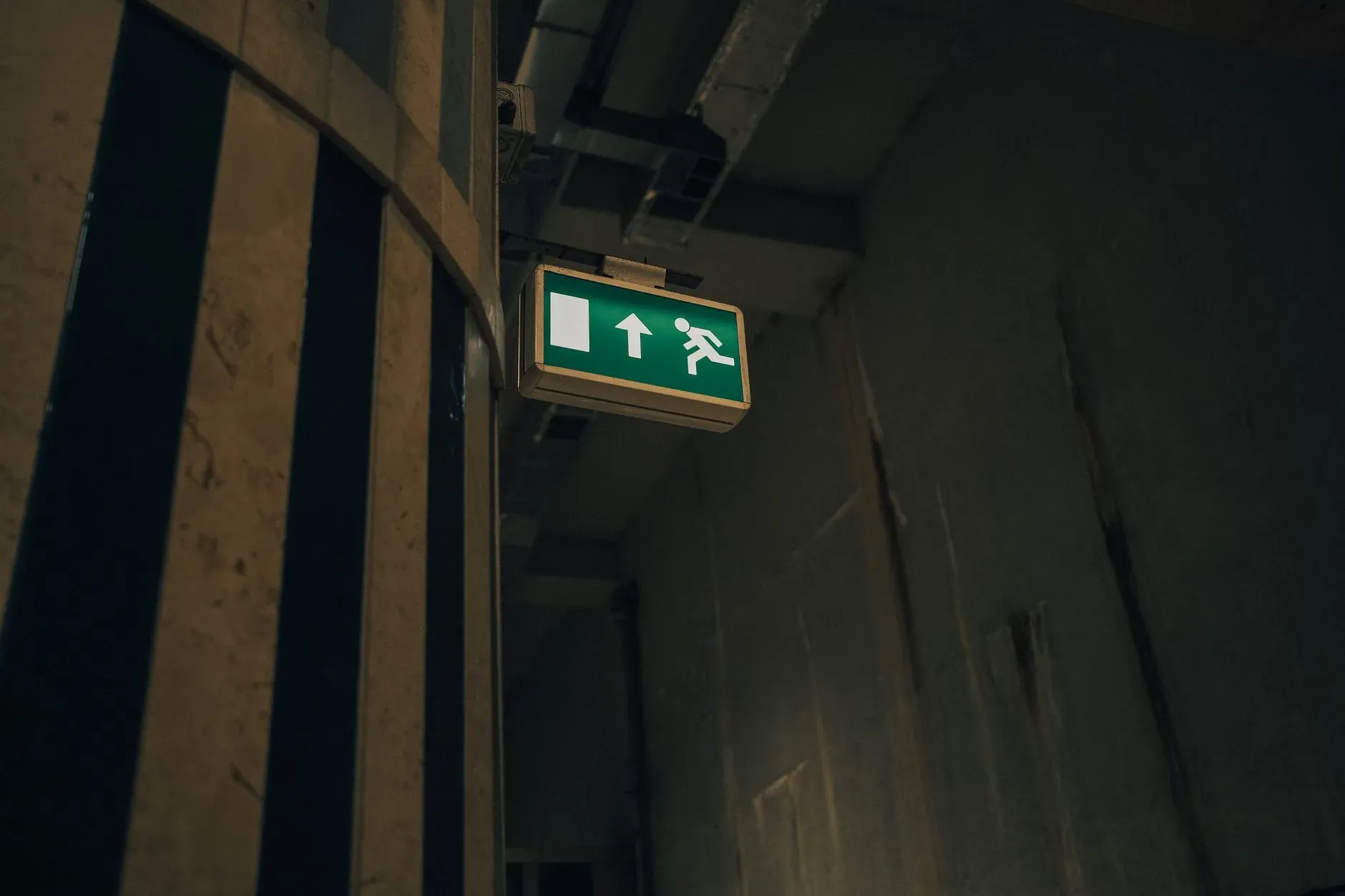 Sinalização de rota de fuga iluminada em corredor de edificação